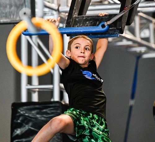 Young boy reaching between rings