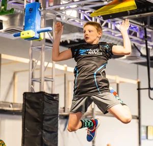 Boy jumping to the next grip