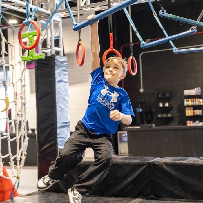 Boy swinging on rings in class